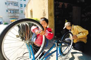 小樂怡與患癌癥的父親一同在店鋪修單車。